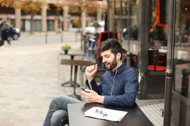 Çocuk akıllı telefon video aramasý ve earphon tarafından kız arkadaşıyla konuşuyor