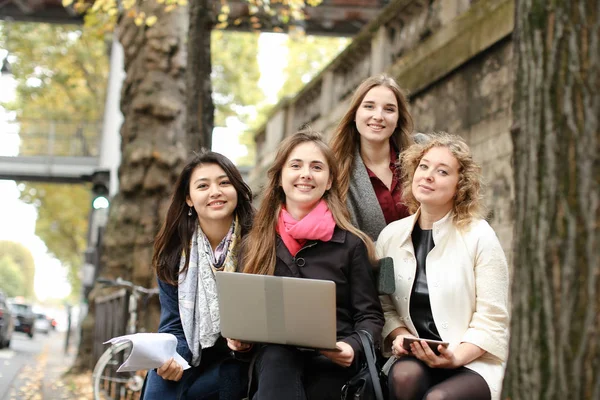 Glättig kvinnliga studenter som sitter på bänken med lärare, laptop, pa — Stockfoto