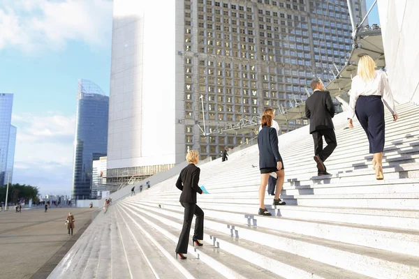 Співробітники задоволені бізнес підійшовши сходи в Парижі ла оборони — стокове фото