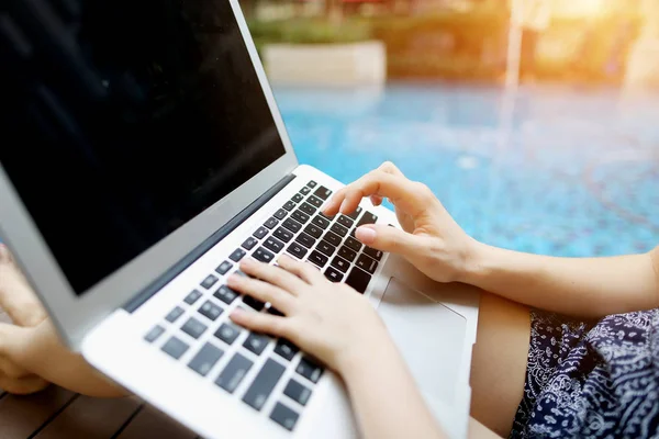 Cerrar manos familiares presionando el teclado en el ordenador portátil día soleado piscina — Foto de Stock