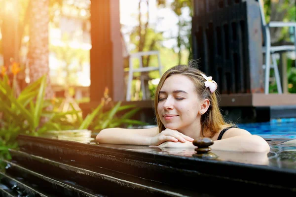 Mujer disfrutar de spa al aire libre en el día soleado en la piscina — Foto de Stock