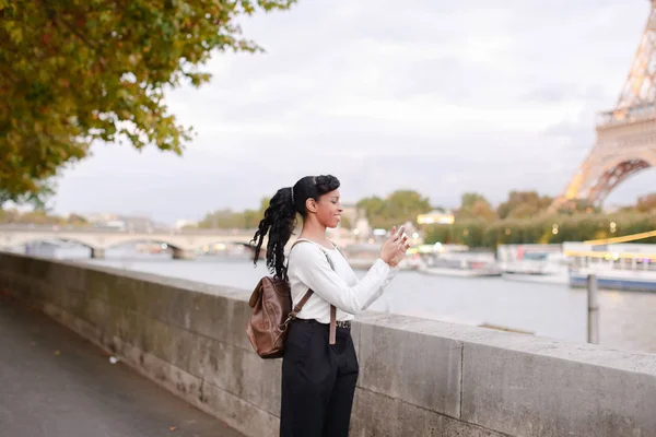 パリの堤防の上に立って、写真を見て若い女性 — ストック写真