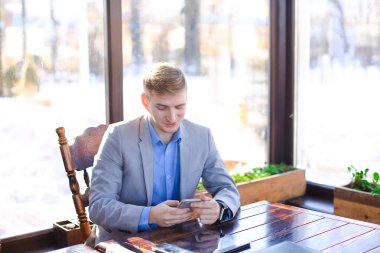 Yanında smartphone tablet yakınındaki kafede chat yapan işadamı.