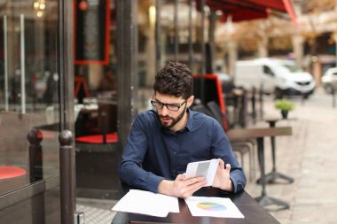 Emlakçı müşteri ile kafeterya masada telefonla konuşuyor