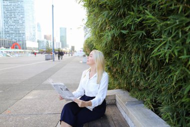 Açık havada yüz yakından ile gazete okuyan Bayan.