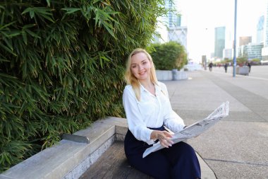 Açık havada yüz yakından ile gazete okuyan Bayan.