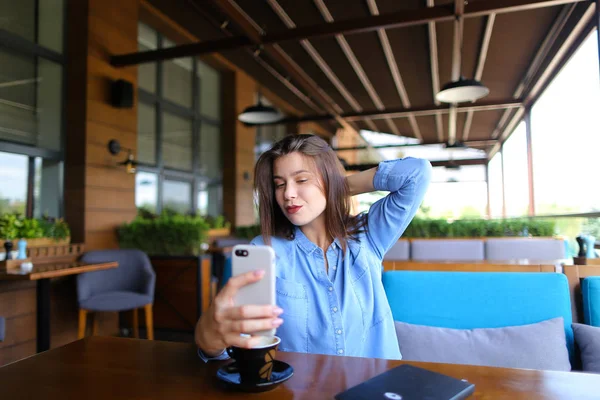 Encantadora chica haciendo selfie por teléfono inteligente con taza de café   . — Foto de Stock