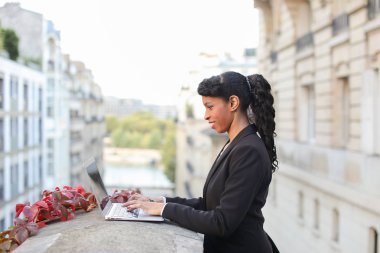 Mix kan emlakçı balkonda laptop ile çalışma.