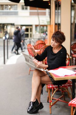    Orta yaşlı bir kadın gazete yeni baskı ele alınmaktadır..