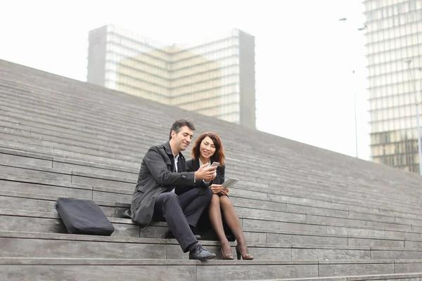 男性と女性会社員が階段に座って休憩を過ごす — ストック写真