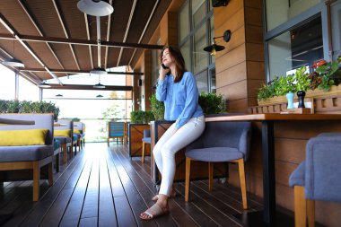 Güzel kadın modeli smartphone tarafından fotoğrafçı ile konuşma 