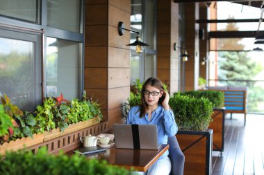 Smartphone ile konuşmak ve laptop ile café'de çalışan serbest meslek