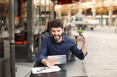 Hoşnutsuz adam online oyun tarafından tablet sokak café'de oynuyor..