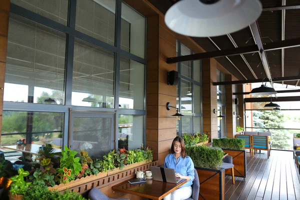 Estudiante charlando por ordenador portátil con amigos en la cafetería . — Foto de Stock