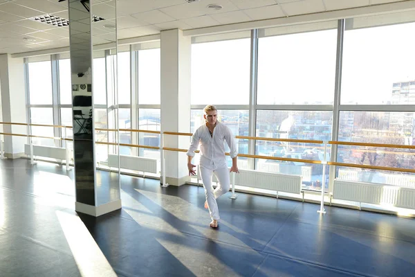 Guy dancing in tectonic style in white suit.