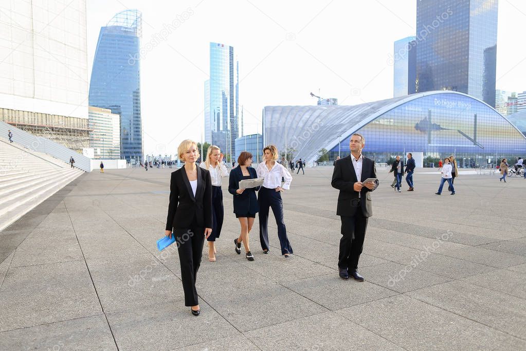 Financial team members passing with tablet, cases and looking at