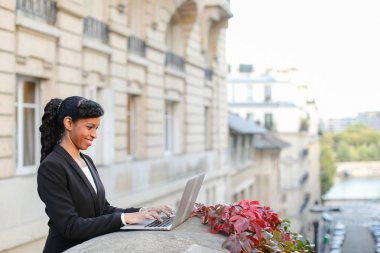 Yarım Afrika işkadını balkonda laptop ile çalışma.