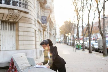 Mix kan emlakçı balkonda laptop ile çalışma.