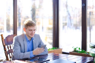 Yanında smartphone tablet yakınındaki kafede chat yapan işadamı.