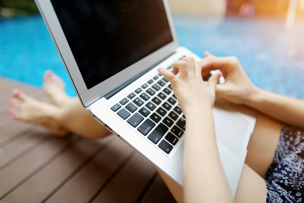 Close up mother and daughter hands pressing keyboard on laptop sunny day swimming pool — Stock Photo, Image