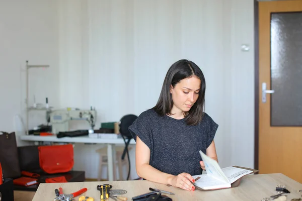 Female making belt to order.