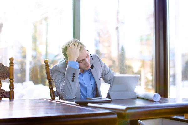 Consultant speaking with client at cafe using tablet and headset