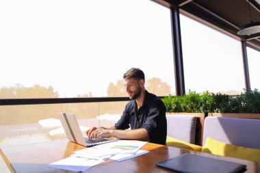 Başarılı foreman kafede dizüstü ve belgeleri kullanma.