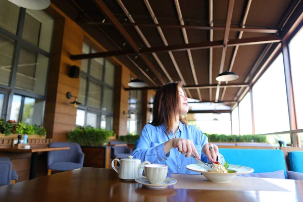 Glad tjej beter vid smartphone på café och äta desser — Stockfoto