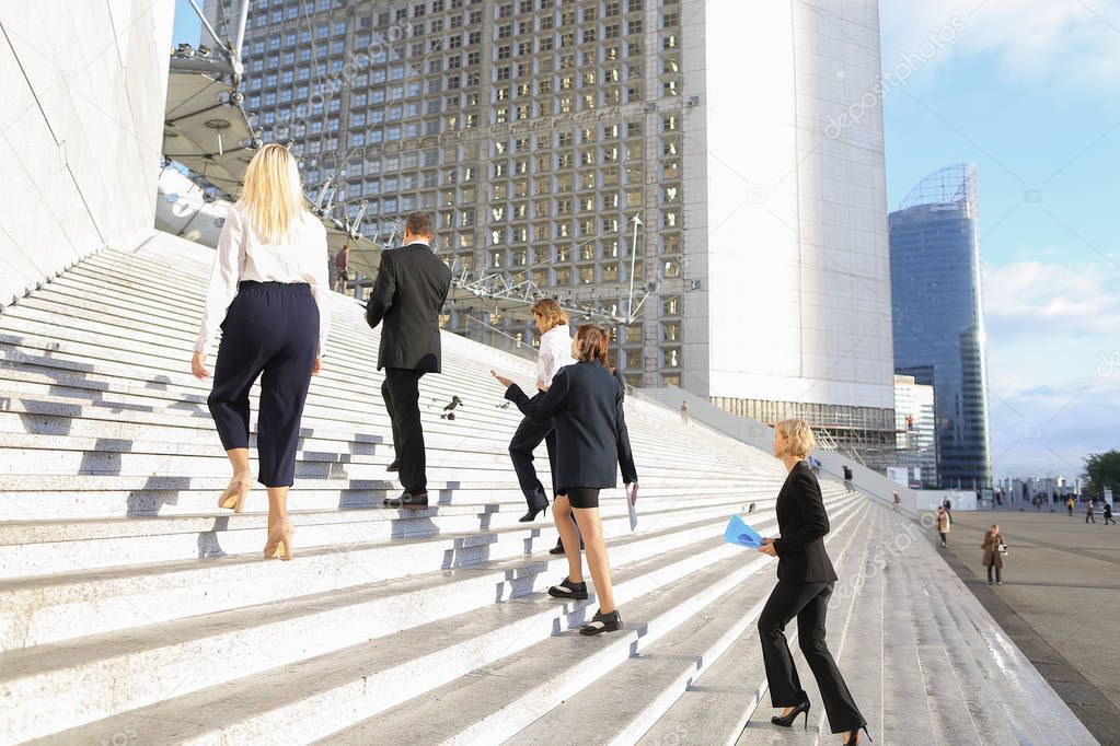 Satisfied business employees going up stairs in La Defense Paris