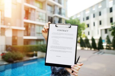 Yeni binanın arka plan karşı genç kız tarafından düzenlenen sözleşme odaklanmak. Açık açık yazı tipi lisansı ile kullanılan