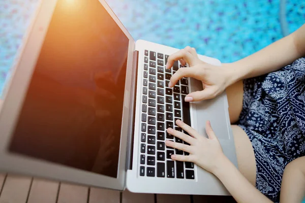 Cerrar las manos de mujer y niño presionando el teclado en la piscina día soleado portátil — Foto de Stock