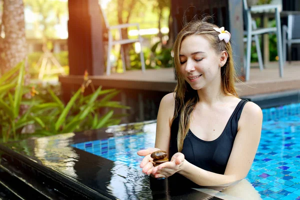 Mujer sosteniendo cairn grupo de piedras, haciendo yoga balance en piscina luz del sol — Foto de Stock