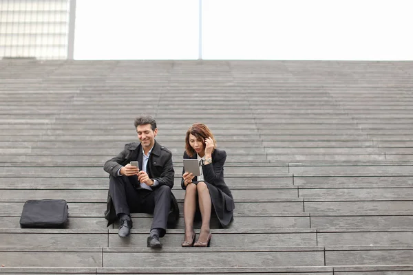 Erkek ve kadın Ofis çalışanları merdiven üzerinde oturan break harcamak — Stok fotoğraf