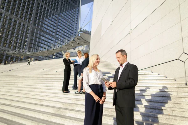 Political scientists going down stairs with tablet and cases.