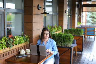 Smartphone ile konuşmak ve laptop ile café'de çalışan serbest meslek