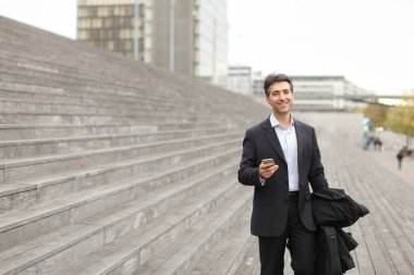      fotoğrafları izlemek için Smartphone kullanarak yürüyüş iş adamı.