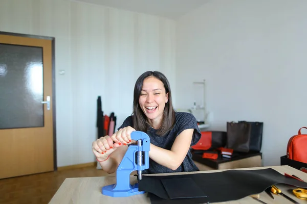 Female making belt to order.