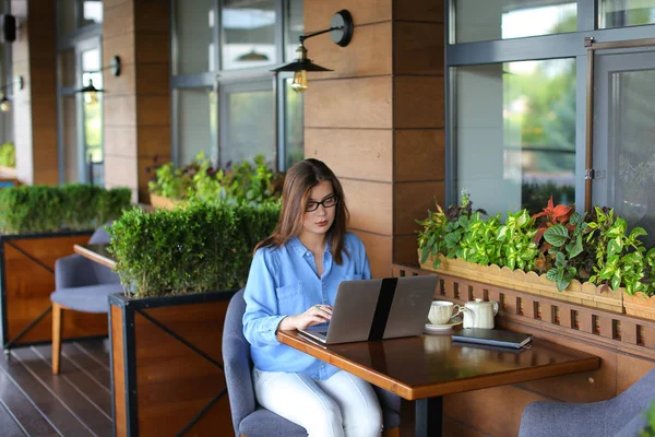 美丽的女孩在咖啡馆里用手提电脑浏览. — 图库照片