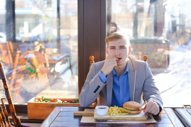 Akıllı izlemek zevk ile gri ceket giymiş işadamı yemek