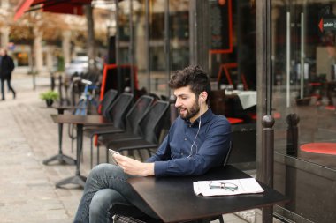 Çocuk akıllı telefon video aramasý ve earphon tarafından kız arkadaşıyla konuşuyor