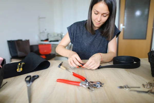 Student learning to sew zipper on purse.