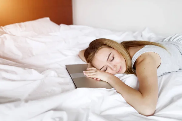 Joven freelance mujer cansado de trabajo conciliar el sueño en el ordenador portátil en la cama ropa blanca en casa — Foto de Stock