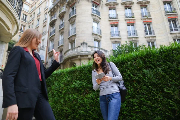 Beautiful girl talking with foreign Chinese student keeping tabl