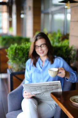 Restoranda gazete okuma ve çay içme büyüleyici kadın 