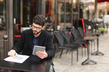 Grafik tasarımcı Tablet ve kağıtları kafeterya masada çalışma