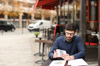 Başarılı işadamı asistanıyla smartphone tarafından c konuşuyor.