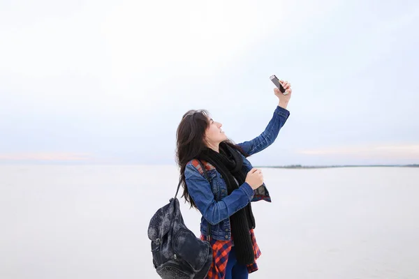 Student teacher female taking selfies with smartphone at sea — Stock Photo, Image