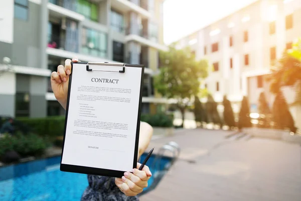 Concéntrese en el documento que sostiene a la niña en el fondo del nuevo edificio de luz solar. Frente utilizado con licencia Open Font — Foto de Stock