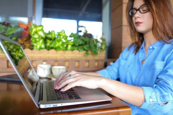 Freelancer falando por smartphone e trabalhando com laptop no café — Fotografia de Stock