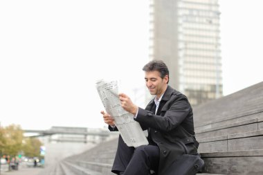      merdivenlerde oturan ve gazete okuyan erkek iş öğretmen